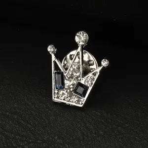 Dettaglio squisito della spilla a corona da uomo con strass scintillanti e pietre blu eleganti.