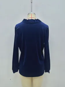 Détail de chemisier à manches longues en velours bleu foncé, col V à volants élégant.