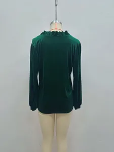 Vue détaillée du chemisier en velours vert foncé à manches longues et col volanté.