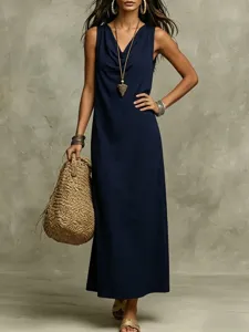 Detail shot of women navy blue sleeveless cowl neck long dress with stylish woven straw bag.