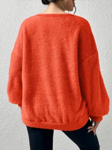 Cozy orange fluffy long sleeve sweatshirt detail showcasing soft fleece texture for casual wear.