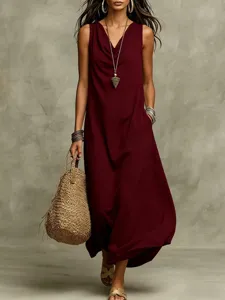 Close-up view of a sleeveless maroon maxi dress paired with a woven straw bag for summer.
