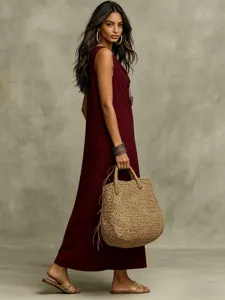 Detailed view of the sleeveless maxi dress in deep red, set against a neutral grey wall.
