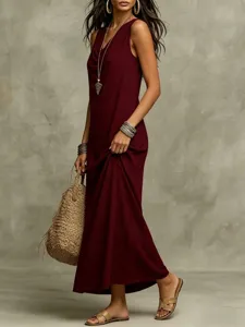 Detailed view of women's elegant burgundy sleeveless maxi dress in a scenic indoor setting.