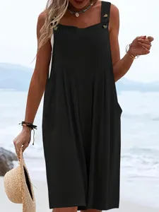 Close-up detail of black sleeveless wide leg jumpsuit with button straps and side pockets.