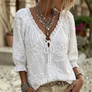 Detailed view of women's white embroidered V-neck tie-front ruffled 3/4 sleeve summer top.
