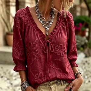 Detailed view of floral embroidered V-neck blouse, bohemian 3/4 sleeve top close-up.