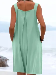 Back view detail of women's sleeveless light green loose wide leg jumpsuit at the beach