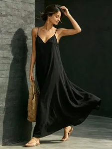 Outdoor detail shot showcasing the elegant black maxi dress with chic V-neck and flowing hemline.