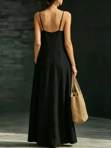 Detail view of backless black slip dress, spaghetti straps, long hem, summer casual style.
