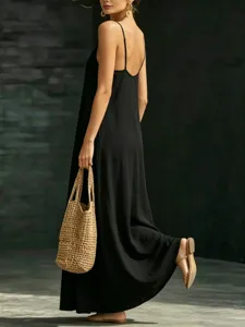 Detail view of the elegant black slip dress showing back straps, maxi length and flowy hem.