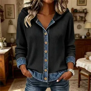 Detailed view of women's denim patchwork ribbed knit hoodie featuring contrast wood buttons and long sleeves.