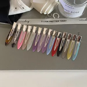 Detailed close-up of colorful narrow acetate hair clips neatly arranged in a row.