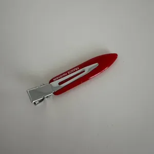 Detailed view of the red acetate narrow hair clip, featuring metallic accent and clean finish.