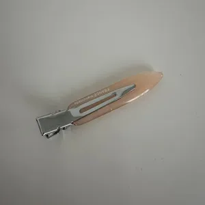 Close-up view of the narrow acetate hair clip showing the metallic clip and smooth surface finish.