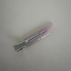 Close-up detail of the pink acetate hair clip with silver metal clip, elegant texture.