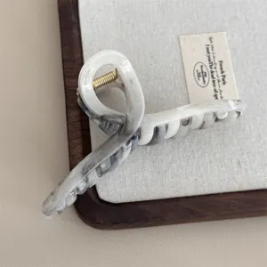 Elegant black and white marble hair claw clip, stylish minimalist hair accessory for women.