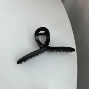 Black minimalist hair claw clip, sleek cross design for elegant daily chic hairstyles.