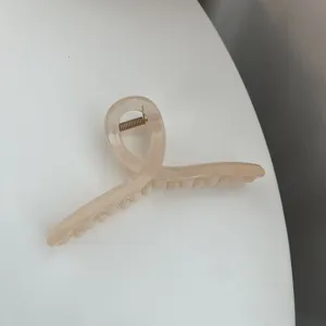 Minimalist geometric hair claw clip detail view, elegant nude tone design for daily styling.