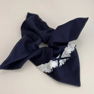 Navy blue hair scrunchie with white lace ruffle and cute bow accent, elegant hair tie accessory.