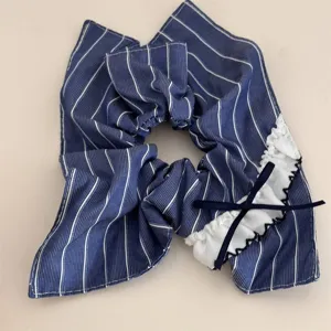 Navy blue striped hair scrunchie with white lace ruffle and cute bow detail accessory.