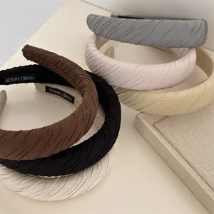 Detailed view of stylish pleated fabric headbands, soft texture and comfortable fit.