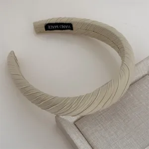 Beige pleated fabric headband detail shot, stylish wide hair accessory for daily wear.