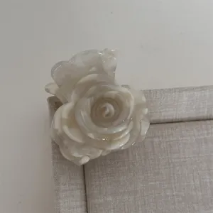 Vue rapprochée d'une pince à cheveux rose blanche effet marbre, accessoire en acrylique.