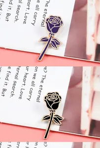 Charmante broche épingle en émail rose métal avec des motifs floraux violets et noirs.