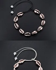 Detail view of the bohemian rose gold electroplated cowrie shell necklace with adjustable cord.