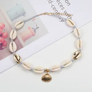 Collana di conchiglie intrecciata a mano stile boho con ciondolo dorato e catena.