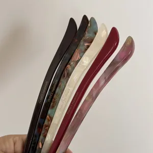 Detail shot of elegant acetate hair sticks in multiple colors, minimalist design for daily wear.
