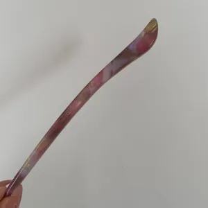 Closeup detail of acetate hair stick with handmade lettering, elegant minimalist design.