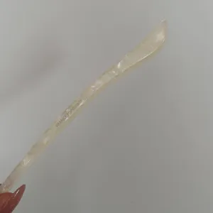 Acetate hair stick detail, minimalist style single hairpin closeup, elegant hair accessory.