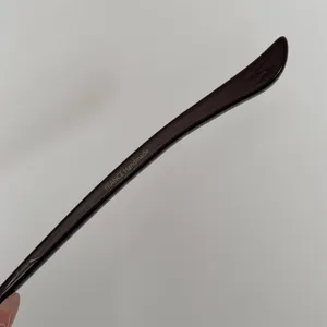 Close-up detail of dark brown acetate hair stick with handmade in France inscription.