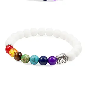 Detail shot of chakra lava stone and white bead bracelet with silver Buddha head charm.