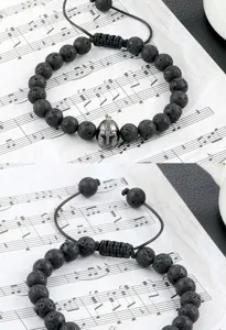 Detailopname van de zwarte lavastenen kralenarmband met een metalen spartaans helmbedeltje.