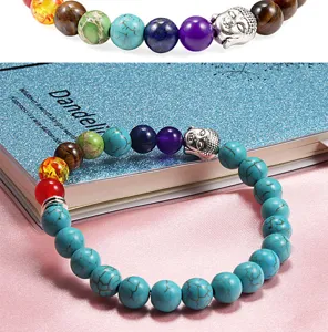 Closeup of chakra stone beaded bracelet with buddha head charm, colorful natural gemstone.