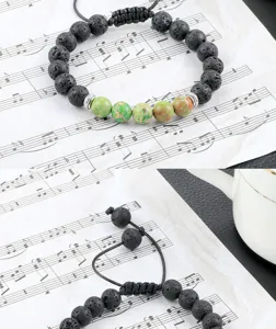 Armband van natuurlijke lavasteen en groene keizerjaspis met verstelbaar geweven koord.
