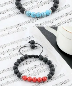 Detail van lavasteen en turquois kralen armband met verstelbaar koord en metalen afstandsdelen.