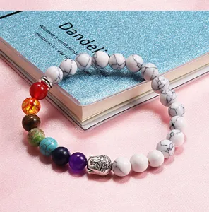 Chakra beaded bracelet detail showing multi-color natural stone beads and buddha charm close up.