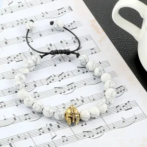 Witte howliet kraal armband met gouden spartaanse helm bedel verstelbaar gevlochten koord sieraad