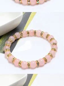 Primo piano del braccialetto di perle in quarzo rosa con distanziatori di strass e anelli.