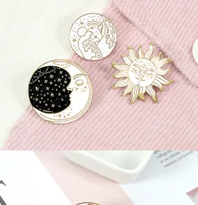 Conjunto de broches esmaltados celestes en blanco y negro con sol, luna y olas.