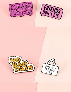 Close-up detail of creative enamel pin badges with funny English quote letters, alloy.