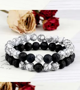 Gros plan détail de ensemble de bracelet de perles en pierre de lave et agate blanche.