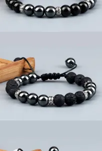 Detailopname van zwarte lavasteen en hematiet kralenarmband met verstelbaar gevlochten koord.