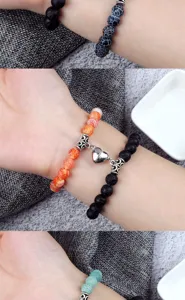 Vue détaillée du bracelet cœur magnétique de couple avec perles de lave et d'agate au poignet.