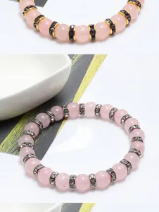 Dettaglio in primo piano del dolce braccialetto di perline in quarzo rosa con strass.
