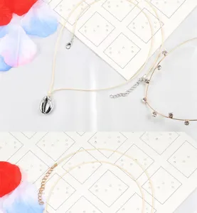Detailansicht einer minimalistischen Muschel Anhänger Halskette und zarten Strasskette.